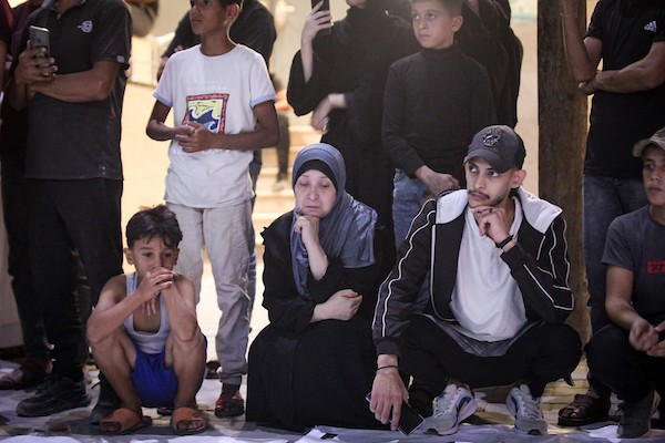 فلسطينيون يشعلون الشموع أمام مستشفى العودة في مخيم النصيرات وسط قطاع غزة، في 28 سبتمبر/أيلول 2026، خلال وداع رفات شهداء. (صورة: معز صالحي)