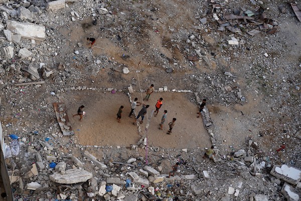 أطفال فلسطينيون يلعبون الكرة الطائرة على ملعب أُقيم بين أنقاض المباني التي دمرتها الحرب في مدينة غزة في 16 سبتمبر/أيلول 2026. صورة: بلال أسامة
