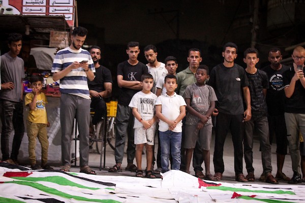 فلسطينيون يشعلون الشموع أمام مستشفى العودة في مخيم النصيرات وسط قطاع غزة، في 28 سبتمبر/أيلول 2026، خلال وداع رفات شهداء. (صورة: معز صالحي)