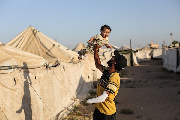 الحلاق جهاد المبحوح (38 عاماً) يواصل عمله داخل خيمة في مخيم النصيرات وسط قطاع غزة، في 20 سبتمبر/أيلول 2026، بعد فقدانه إحدى يديه إثر إصابته في غارة إسرائيلية. (صورة: حسن الجدي)