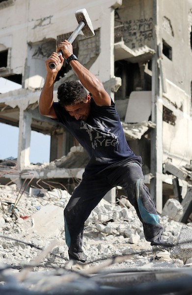 عمال فلسطينيون يزيلون أنقاض منزل دُمر في غارة إسرائيلية خلال الحرب في حي الرمال بمدينة غزة، في 14 سبتمبر/أيلول 2026. تصوير: بلال أسامة.
