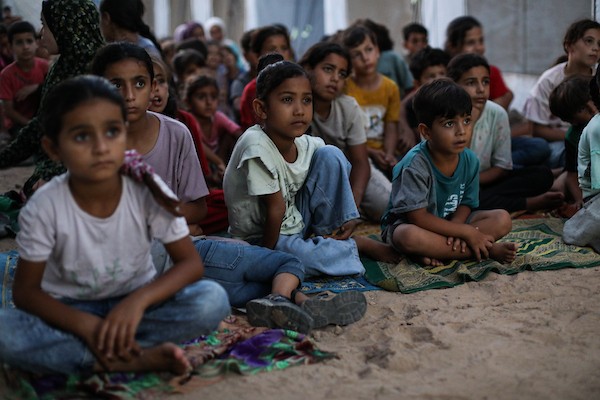 أطفال فلسطينيون يشاهدون رسومًا متحركة في مخيم النصيرات للاجئين وسط قطاع غزة، في 18 سبتمبر/أيلول 2026. تصوير: حسن الجدي