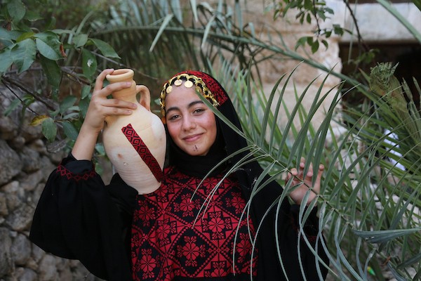 فتيات فلسطينيات يرتدين أزياءً وطنية تقليدية مطرزة بالحرير يقفن على جسر حديدي في الموقع الأثري بمدينة سبسطية، غرب نابلس شمال الضفة الغربية. (تصوير: محمد ناصر )