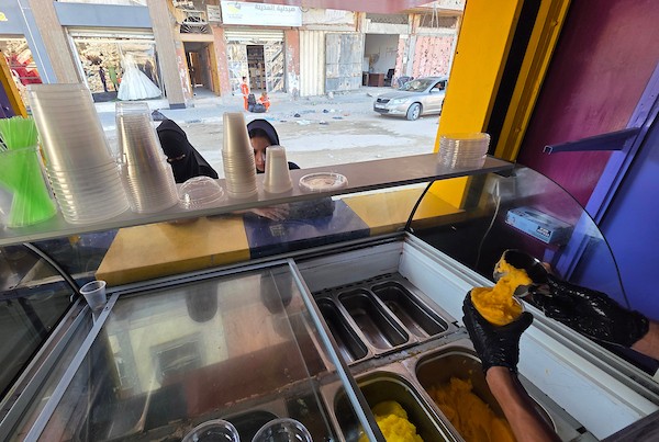 عمال فلسطينيون يواصلون العمل داخل مصنع للعصائر والآيس كريم في خان يونس، جنوب قطاع غزة، بعد استئناف الإنتاج بإمكانات محدودة(تصوير: طارق محمد)