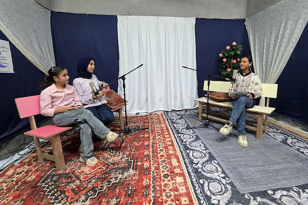 أطفال فلسطينيون يشاركون في إعداد وتقديم برامج لقناة طلائع فلسطين من استوديو متواضع أُقيم داخل خيام النزوح في منطقة مواصي خان يونس. (تصوير: طارق محمد)