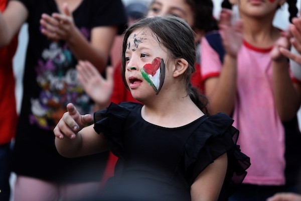 تجمّع أطفال فلسطينيون لمشاهدة عرض فيلم كرتوني في الهواء الطلق على شاشة نُصبت بين المباني المتضررة في مخيم للنازحين بحي النصر في مدينة غزة، وذلك في 2 سبتمبر/أيلول 2026.(صورة: بلال أسامة)