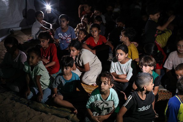 أطفال فلسطينيون يشاهدون رسومًا متحركة في مخيم النصيرات للاجئين وسط قطاع غزة، في 18 سبتمبر/أيلول 2026. تصوير: حسن الجدي