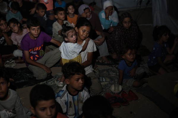 أطفال فلسطينيون يشاهدون رسومًا متحركة في مخيم النصيرات للاجئين وسط قطاع غزة، في 18 سبتمبر/أيلول 2026. تصوير: حسن الجدي