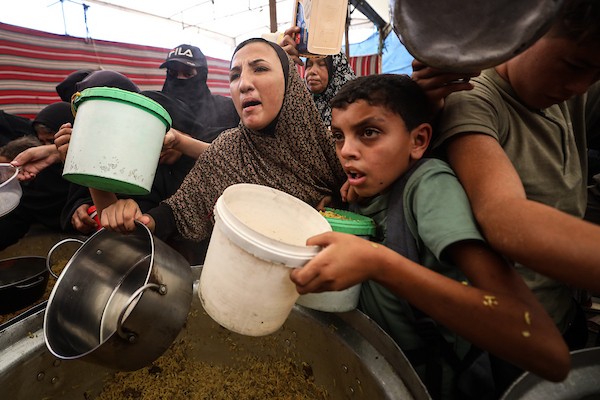 فلسطينيون نازحون، ينتظرون الحصول على وجبات ساخنة في مخيم النصيرات للاجئين وسط قطاع غزة، في 28 سبتمبر/أيلول 2026. (صورة: حسن الجدي)