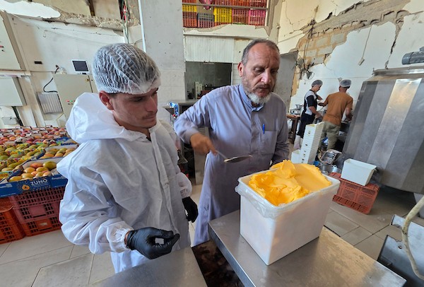 عمال فلسطينيون يواصلون العمل داخل مصنع للعصائر والآيس كريم في خان يونس، جنوب قطاع غزة، بعد استئناف الإنتاج بإمكانات محدودة(تصوير: طارق محمد)