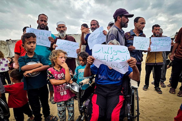في 26 سبتمبر/أيلول 2026، قرع فلسطينيون نازحون أواني الطبخ خلال احتجاج في مقبرة بخان يونس، جنوب قطاع غزة.(صورة: طارق)