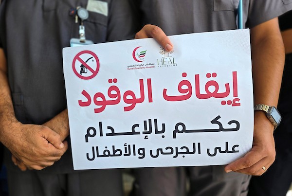 أطباء وممرضون يقفون خارج أقسام مستشفى الكويت الميداني التخصصي في قطاع غزة، في 20 سبتمبر/أيلول 2026، بعد إعلان تعليق العمل واستقبال المرضى بسبب انقطاع إمدادات الوقود. (صورة: طارق محمد)
