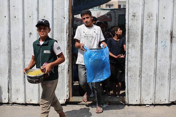 فلسطينيون نازحون، ينتظرون الحصول على وجبات ساخنة في مخيم النصيرات للاجئين وسط قطاع غزة، في 28 سبتمبر/أيلول 2026. (صورة: حسن الجدي)