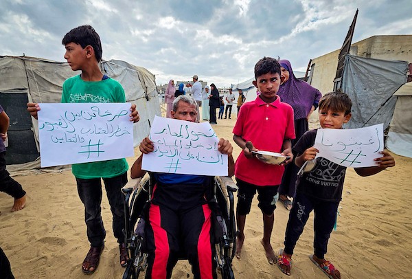في 26 سبتمبر/أيلول 2026، قرع فلسطينيون نازحون أواني الطبخ خلال احتجاج في مقبرة بخان يونس، جنوب قطاع غزة.(صورة: طارق)