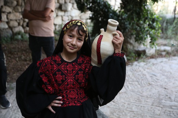 فتيات فلسطينيات يرتدين أزياءً وطنية تقليدية مطرزة بالحرير يقفن على جسر حديدي في الموقع الأثري بمدينة سبسطية، غرب نابلس شمال الضفة الغربية. (تصوير: محمد ناصر )