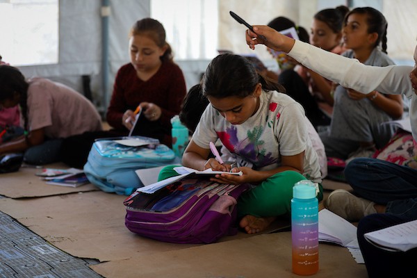 أطفال فلسطينيون يحضرون درساً داخل خيمة تعليمية مؤقتة، جالسين على الأرض في غرب مدينة غزة، في 20 سبتمبر/أيلول 2026.صورة: بلال أسامة
