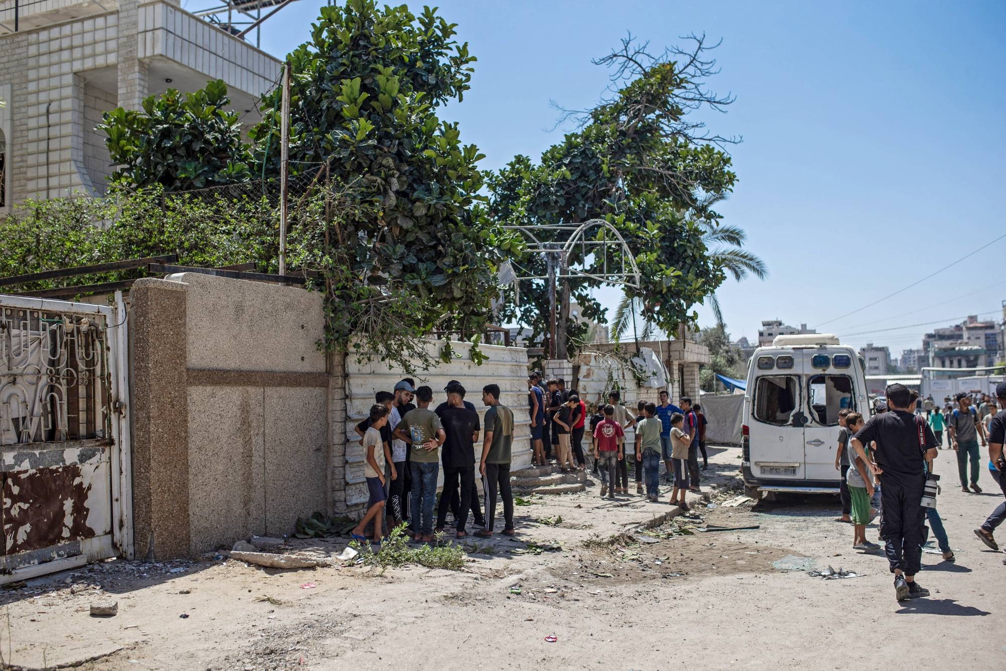 فلسطينيون قرب منزل مسؤول أمني في «حماس» تعرض لهجوم إسرائيلي أسفر عن اختطافه يوم الثلاثاء (إ.ب.أ).jpeg
