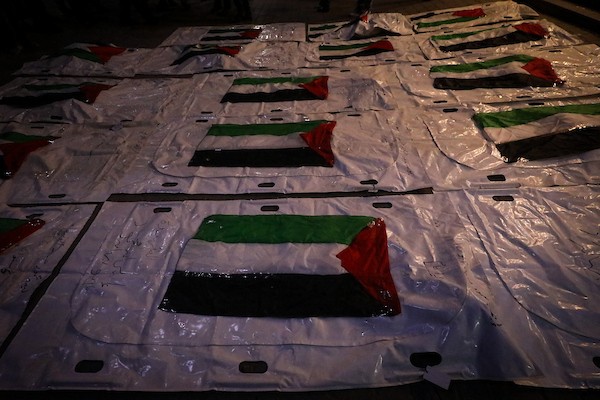 فلسطينيون يشعلون الشموع أمام مستشفى العودة في مخيم النصيرات وسط قطاع غزة، في 28 سبتمبر/أيلول 2026، خلال وداع رفات شهداء. (صورة: معز صالحي)