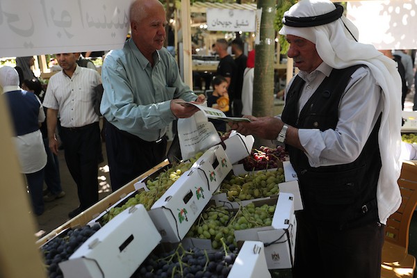 مزارعون وسكان فلسطينيون يشاركون في مهرجان «أيام العنب الخليلي» في البلدة القديمة بمدينة الخليل، في 26 سبتمبر/أيلول 2026. تصوير: مأمون وزوز.