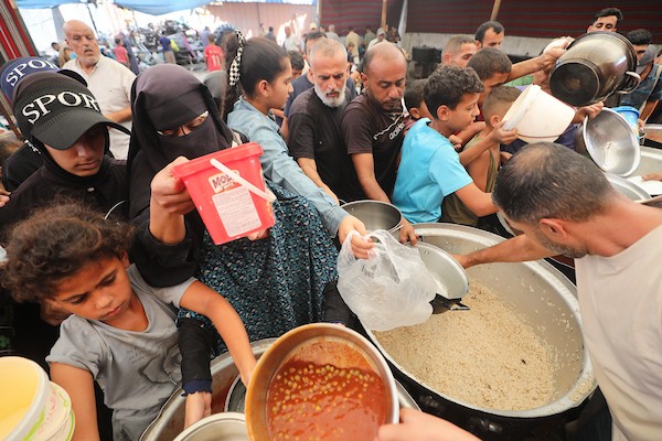فلسطينيون نازحون، بينهم أطفال، يتجمعون للحصول على وجبات ساخنة في مخيم النصيرات وسط قطاع غزة، في 19 أيلول/ سبتمبر 2026. (تصوير: حسن الجدي)