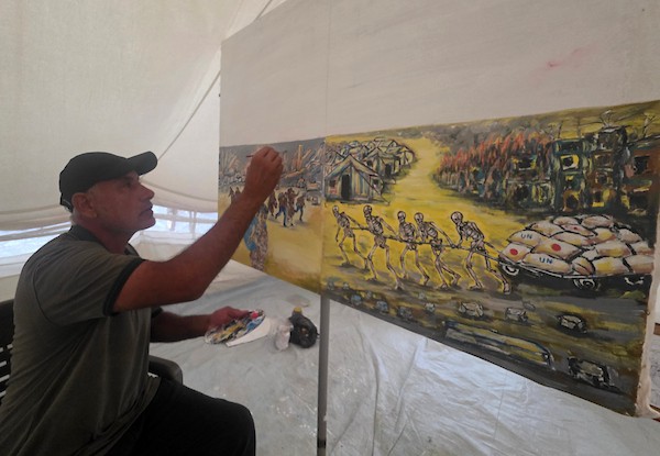 الفنان الفلسطيني جهاد الشرافي يرسم داخل خيمة للنازحين في خان يونس جنوبي قطاع غزة، مشاهد توثق الحرب والجوع ونقص المياه والدمار، في 18 سبتمبر/أيلول 2026. تصوير: طارق محمد