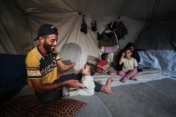 الحلاق جهاد المبحوح (38 عاماً) يواصل عمله داخل خيمة في مخيم النصيرات وسط قطاع غزة، في 20 سبتمبر/أيلول 2026، بعد فقدانه إحدى يديه إثر إصابته في غارة إسرائيلية. (صورة: حسن الجدي)
