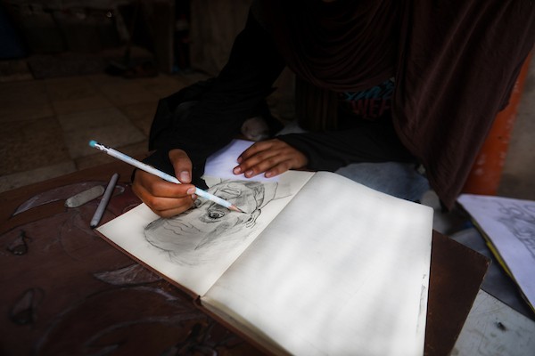رغد حداد، فتاة فلسطينية تبلغ من العمر 16 عامًا، ترسم داخل خيمة للنازحين في حي الشيخ رضوان بمدينة غزة في 23 سبتمبر/أيلول 2026. تصوير: بلال أسامة