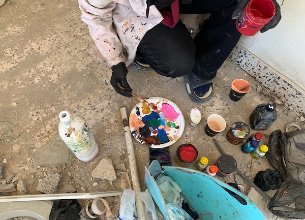 الفنانة الفلسطينية أسيل نسمان ترسم عملًا فنيًا على أنقاض منازل مدمرة في قطاع غزة، في 24 سبتمبر/أيلول 2026. (صورة: محمد صالحة)