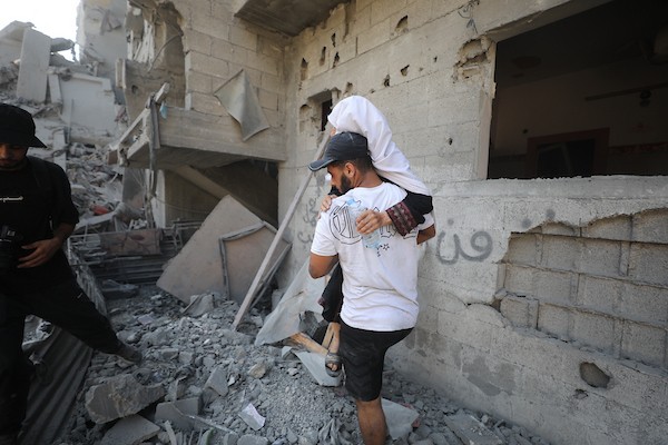 فلسطينيون يتفقدون مبنىً دُمر في غارة جوية إسرائيلية بمخيم النصيرات للاجئين وسط قطاع غزة في 9 سبتمبر/أيلول. صورة: حسن الجدي