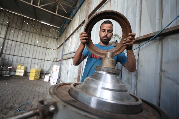 عامل فلسطيني يصلح إحدى معاصر الزيتون في دير البلح، وسط قطاع غزة، في 27 سبتمبر/أيلول 2026، قبيل موسم القطاف. صورة: حسن الجدي
