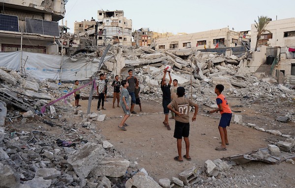 أطفال فلسطينيون يلعبون الكرة الطائرة على ملعب أُقيم بين أنقاض المباني التي دمرتها الحرب في مدينة غزة في 16 سبتمبر/أيلول 2026. صورة: بلال أسامة
