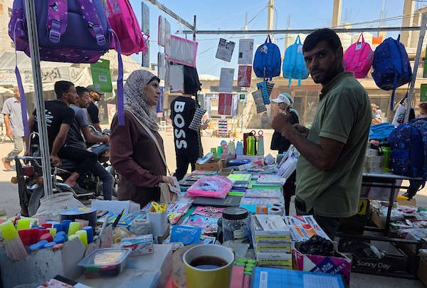 يتسوق فلسطينيون حقائب وأدوات مكتبية ولوازم مدرسية أخرى من أكشاك في سوق خان يونس، 13 سبتمبر/أيلول 2026. (صورة: طارق محمد