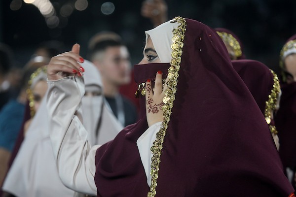 عرسان يشاركون في حفل زفاف جماعي ضم 44 زوجًا في مدينة دورا قرب الخليل، في 26 سبتمبر/أيلول 2026. تصوير: مأمون وزواز.
