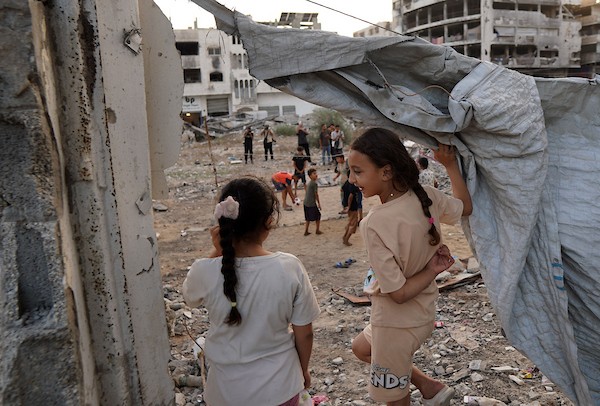 أطفال فلسطينيون يلعبون الكرة الطائرة على ملعب أُقيم بين أنقاض المباني التي دمرتها الحرب في مدينة غزة في 16 سبتمبر/أيلول 2026. صورة: بلال أسامة