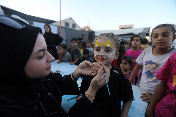 تجمّع أطفال فلسطينيون لمشاهدة عرض فيلم كرتوني في الهواء الطلق على شاشة نُصبت بين المباني المتضررة في مخيم للنازحين بحي النصر في مدينة غزة، وذلك في 2 سبتمبر/أيلول 2026.(صورة: بلال أسامة)