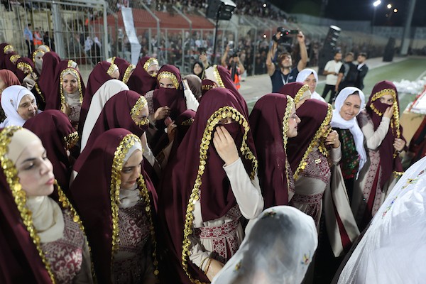 عرسان يشاركون في حفل زفاف جماعي ضم 44 زوجًا في مدينة دورا قرب الخليل، في 26 سبتمبر/أيلول 2026. تصوير: مأمون وزواز.