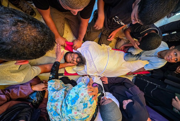 الممرضة عزة أبو مصطفى تستقبل جثمان والدها في مجمع ناصر الطبي بمخيم خان يونس، جنوب قطاع غزة، أثناء مناوبتها، بعد استشهاده في غارة إسرائيلية، 7 أكتوبر/تشرين الأول 2026. تصوير: طارق محمد.