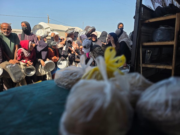 نازحون فلسطينيون يتلقون مساعدات غذائية من مطبخ خيري في مواصي خان يونس، جنوب قطاع غزة، 23 أكتوبر 2026. (تصوير: طارق محمد)