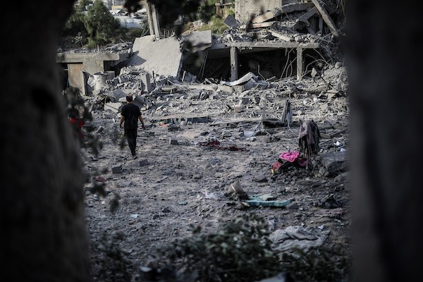 فلسطينيون يتفقدون ممتلكاتهم وسط أنقاض مبنى سكني استهدفته غارة جوية إسرائيلية في حي اليرموك بمدينة غزة، يوم 16 أكتوبر/تشرين الأول 2026. (تصوير: محمد صالحة)