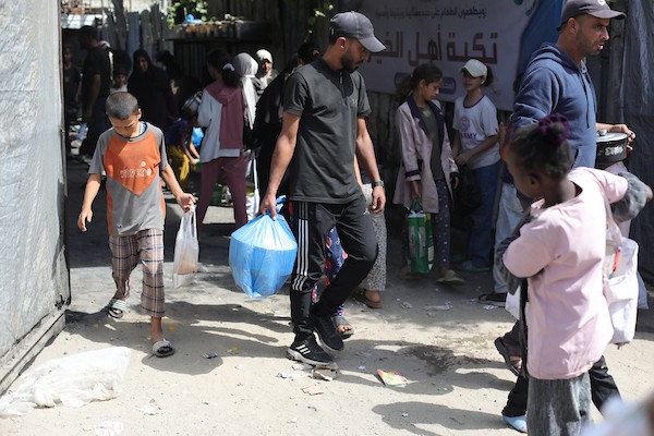 فلسطينيون نازحون يتجمعون للحصول على وجبات غذائية من مطبخ خيري في مخيم النصيرات وسط قطاع غزة، في 8 أكتوبر/تشرين الأول 2026.تصوير: حسن الجدي