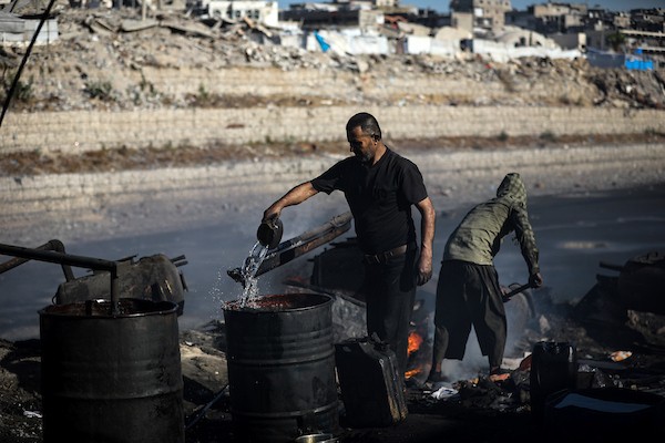 عمال فلسطينيون يجمعون ويفرزون النفايات البلاستيكية لإنتاج وقود بديل باستخدام أفران بدائية، في حي الشيخ رضوان شمال مدينة غزة، لمواجهة شح المحروقات الناجم عن الحصار الإسرائيلي، 29 أكتوبر 2026. (تصوير: محمد صالحة)