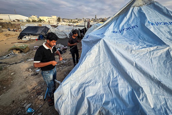 عائلات نازحة تقيم داخل خيام نُصبت بين القبور في إحدى مقابر خان يونس جنوبي قطاع غزة، في 14 أكتوبر/تشرين الأول 2026. (تصوير: طارق محمد)