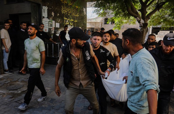 مشيّعون يودّعون جثامين ثلاثة فلسطينيين، بينهم الزوجان أكرم ياسين ودينا أبو بكر، في مستشفى الشفاء بمدينة غزة، ، 20 أكتوبر/تشرين الأول 2026.تصوير: محمد صالحة