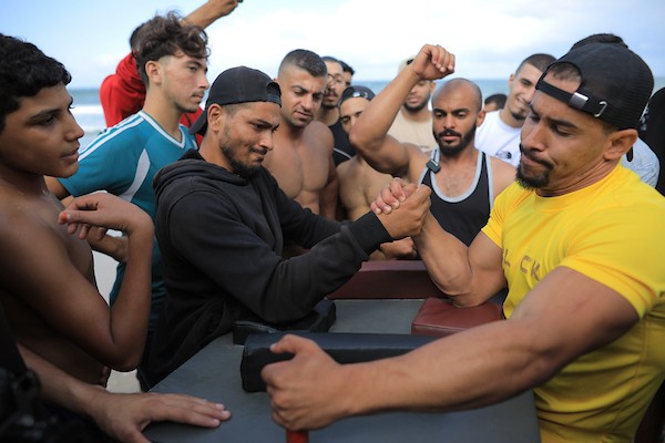 شبان فلسطينيون يمارسون تمارين وأنشطة رياضية على شاطئ النصيرات وسط قطاع غزة، يوم 16 أكتوبر/تشرين الأول 2026. (تصوير: حسن الجدي)