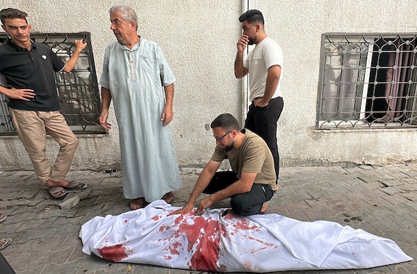 فلسطينيون ينوحون على رجل في مستشفى الشفاء بعد استشهاده في غارة جوية إسرائيلية استهدفت خيمة في مدينة غزة، في 2 أكتوبر/تشرين الأول 2026. صورة: هادي داود