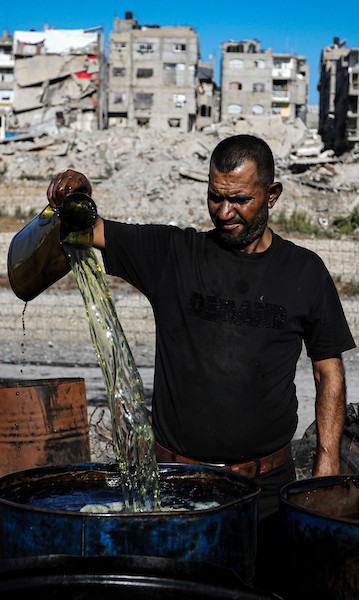عمال فلسطينيون يجمعون ويفرزون النفايات البلاستيكية لإنتاج وقود بديل باستخدام أفران بدائية، في حي الشيخ رضوان شمال مدينة غزة، لمواجهة شح المحروقات الناجم عن الحصار الإسرائيلي، 29 أكتوبر 2026. (تصوير: محمد صالحة)