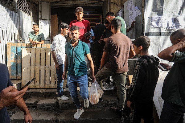 فلسطينيون ينتظرون الحصول على الخبز أمام مخبز في حي الدرج بمدينة غزة، وسط تحذيرات من توقف المخابز المتبقية بسبب نفاد الطحين، 22 أكتوبر 2026. (تصوير: محمد صالحة)