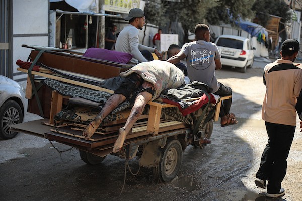 فلسطينيون ينقلون جثمان رجل إلى مستشفى العودة بمخيم النصيرات وسط قطاع غزة، بعد مقتله في غارة إسرائيلية استهدفت مركبة «توك توك» قرب جسر وادي غزة شمال المخيم، 20 أكتوبر/تشرين الأول 2026.تصوير: حسن الجدي
