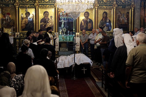 أشخاص يتجمعون خلال جنازة امرأتين مسيحيتين (أم و ابنتها) فلسطينيتين في كنيسة القديس بورفيريوس للروم الأرثوذكس في مدينة غزة، في 3 أكتوبر 2026. تصوير بلال أسامة