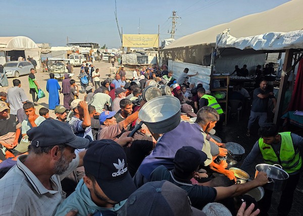 نازحون فلسطينيون يتلقون مساعدات غذائية من مطبخ خيري في مواصي خان يونس، جنوب قطاع غزة، 23 أكتوبر 2026. (تصوير: طارق محمد)